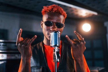 Ses alıştırması yapıyorum. Genç Afrikalı Amerikalı sanatçı bir kayıt stüdyosunda prova yapıyor..