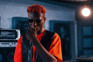 Ses alıştırması yapıyorum. Genç Afrikalı Amerikalı sanatçı bir kayıt stüdyosunda prova yapıyor..