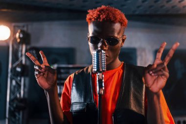 Ses alıştırması yapıyorum. Genç Afrikalı Amerikalı sanatçı bir kayıt stüdyosunda prova yapıyor..