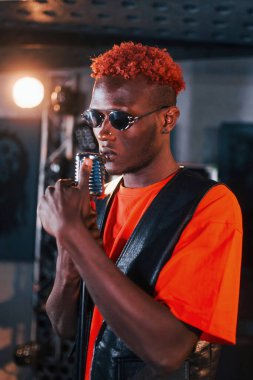 Ses alıştırması yapıyorum. Genç Afrikalı Amerikalı sanatçı bir kayıt stüdyosunda prova yapıyor..