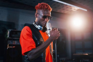 Ses alıştırması yapıyorum. Genç Afrikalı Amerikalı sanatçı bir kayıt stüdyosunda prova yapıyor..