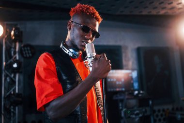 Ses alıştırması yapıyorum. Genç Afrikalı Amerikalı sanatçı bir kayıt stüdyosunda prova yapıyor..