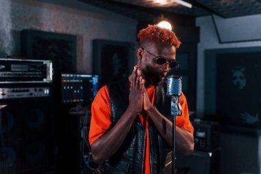 Ses alıştırması yapıyorum. Genç Afrikalı Amerikalı sanatçı bir kayıt stüdyosunda prova yapıyor..