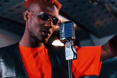 Ses alıştırması yapıyorum. Genç Afrikalı Amerikalı sanatçı bir kayıt stüdyosunda prova yapıyor..