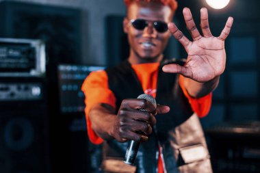 Genç Afrikalı Amerikalı sanatçı bir kayıt stüdyosunda prova yapıyor..