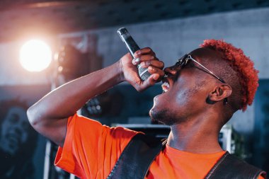 Ses alıştırması yapıyorum. Genç Afrikalı Amerikalı sanatçı bir kayıt stüdyosunda prova yapıyor..