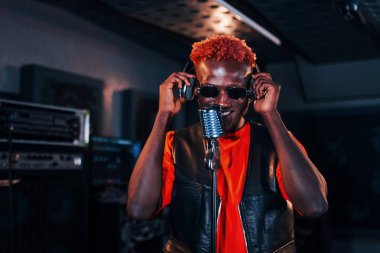 Genç Afrikalı Amerikalı sanatçı bir kayıt stüdyosunda prova yapıyor..