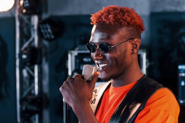 Genç Afrikalı Amerikalı sanatçı bir kayıt stüdyosunda prova yapıyor..