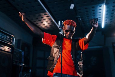 Genç Afrikalı Amerikalı sanatçı bir kayıt stüdyosunda prova yapıyor..