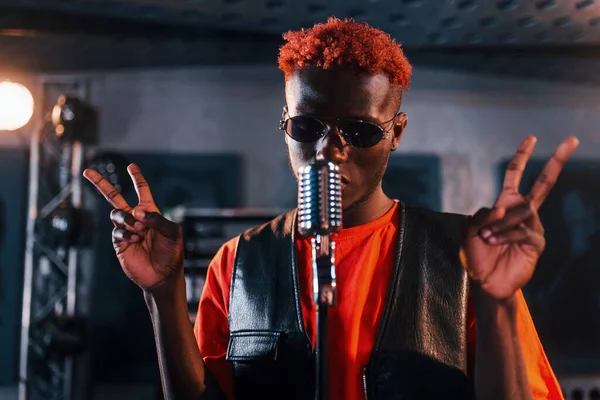 Ses alıştırması yapıyorum. Genç Afrikalı Amerikalı sanatçı bir kayıt stüdyosunda prova yapıyor..