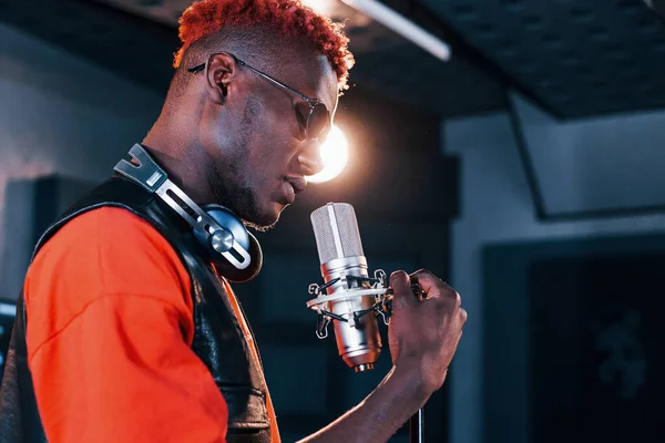 Genç Afrikalı Amerikalı sanatçı bir kayıt stüdyosunda prova yapıyor..