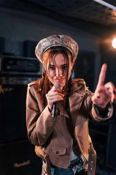 Genç ve güzel bir bayan şarkıcı bir kayıt stüdyosunda prova yapıyor..