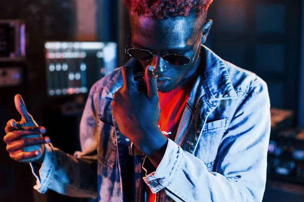 Genç Afrikalı Amerikalı sanatçı bir kayıt stüdyosunda prova yapıyor..