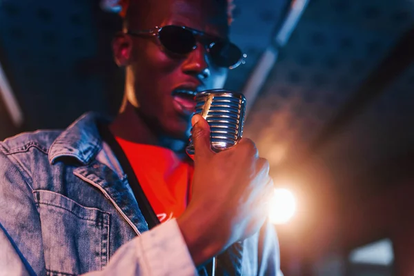 Genç Afrikalı Amerikalı sanatçı bir kayıt stüdyosunda prova yapıyor..