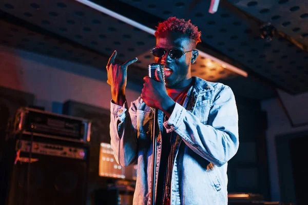 Genç Afrikalı Amerikalı sanatçı bir kayıt stüdyosunda prova yapıyor..