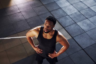 Spor elbiseli güçlü Afrikalı Amerikalı adam spor salonunda antrenman yapıyor..