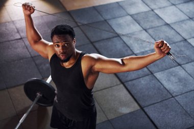 Üst Manzara. Halter yere düştü. Spor elbiseli güçlü Afrikalı Amerikalı adam spor salonunda antrenman yapıyor..