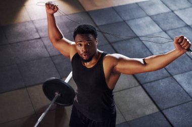 Üst Manzara. Halter yere düştü. Spor elbiseli güçlü Afrikalı Amerikalı adam spor salonunda antrenman yapıyor..