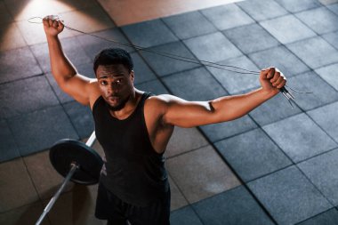 Üst Manzara. Halter yere düştü. Spor elbiseli güçlü Afrikalı Amerikalı adam spor salonunda antrenman yapıyor..