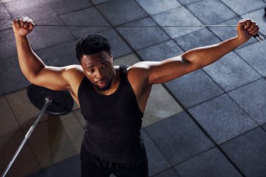 Üst Manzara. Halter yere düştü. Spor elbiseli güçlü Afrikalı Amerikalı adam spor salonunda antrenman yapıyor..