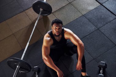 Mola verdim. Spor elbiseli güçlü Afrikalı Amerikalı adam spor salonunda antrenman yapıyor..