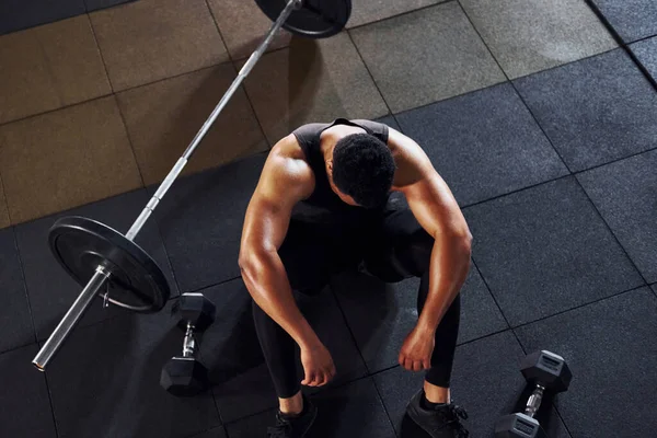 Mola verdim. Spor elbiseli güçlü Afrikalı Amerikalı adam spor salonunda antrenman yapıyor..