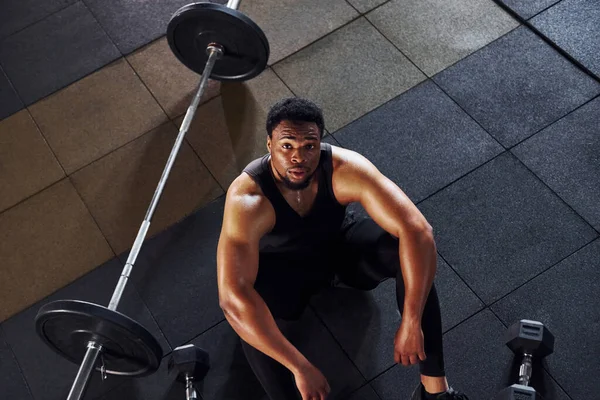 Mola verdim. Spor elbiseli güçlü Afrikalı Amerikalı adam spor salonunda antrenman yapıyor..