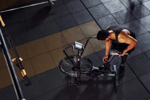 Bisiklete binmek. Spor elbiseli güçlü Afrikalı Amerikalı adam spor salonunda antrenman yapıyor..