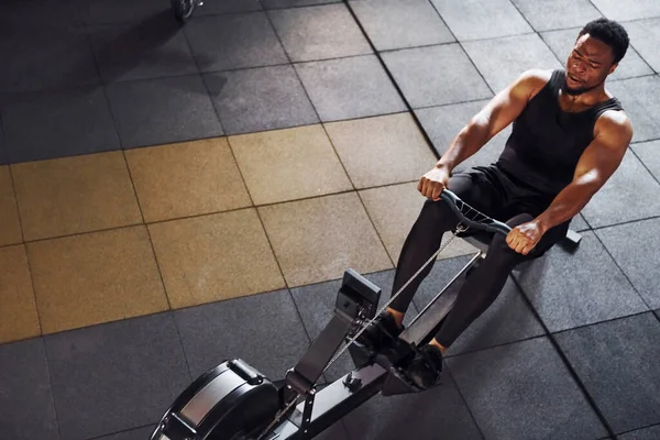Güçlü Afro-Amerikan spor elbiseli adam spor salonunda spor yapıyor ve ekipman kullanıyor. Güç ve güç kavramı.
