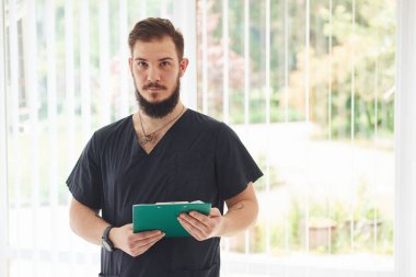 Rehabilitasyon merkezinde kapalı bir yerde duran eğitmenin portresi..