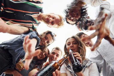 Aşağıya bakıyorum. Aşağıdan bak. Gündelik giysiler içinde bir grup genç gündüz vakti çatıda parti veriyor..