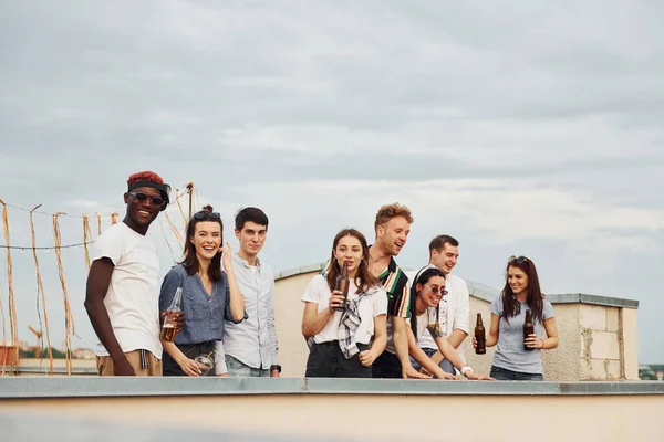 Süslü bir yer. Hava bulutlu. Gündelik giysiler içinde bir grup genç gündüz vakti çatıda parti veriyor..