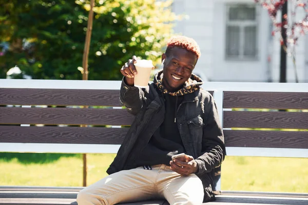 Telefonnal Egy Pohár Itallal Fiatal Afro Amerikai Férfi Fekete Kabátban — Stock Fotó