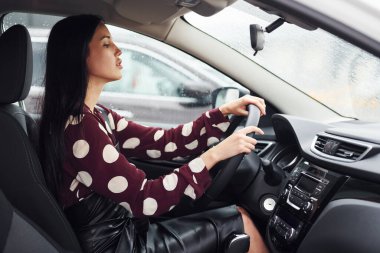 Modern otomobilin içinde güzel, genç bir esmer. Sür arabayı..