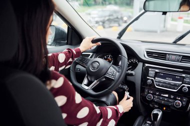 Modern otomobilin içindeki genç ve güzel esmerin yakın görüntüsü. Sür arabayı..