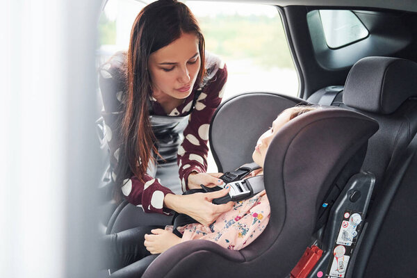 Мать с дочерью в современном автомобиле вместе.