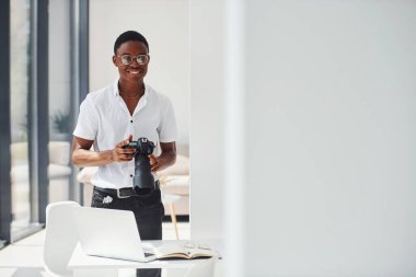 Kamera test ediliyor. Resmi giyinmiş genç Afro-Amerikan adam ofiste..