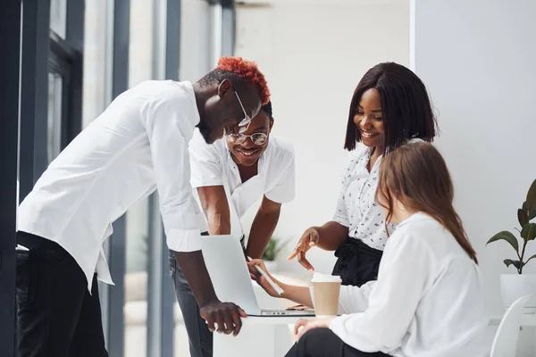 Using laptop. Group of african american business people working in office together.