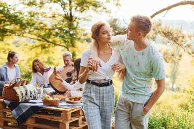 Mutlu bir çift. Bir grup gencin dışarıda, ormanda tatili var. Hafta sonu ve arkadaşlık kavramı.