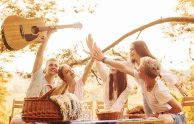 Birbirlerine beşlik çakıyorlar. Bir grup gencin dışarıda, ormanda tatili var. Hafta sonu ve arkadaşlık kavramı.