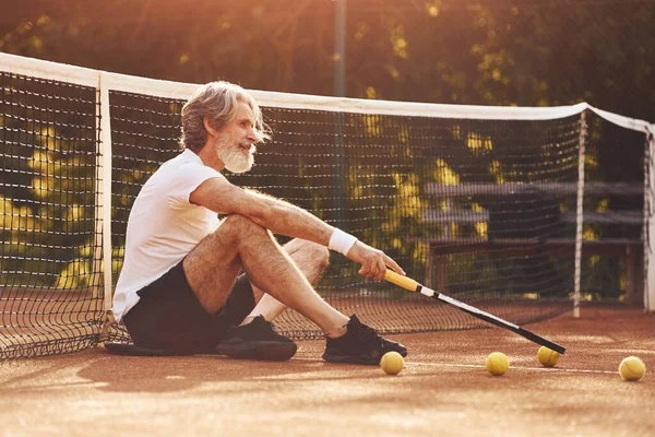 Oturup ara veriyoruz. Beyaz gömlekli ve tenis kortunda siyah şortlu son sınıf stil sahibi bir adam..