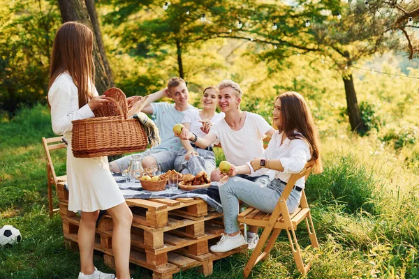 女人拿着篮子和食物 一群年轻人在森林里出去度假 周末和友谊的概念 — 图库照片