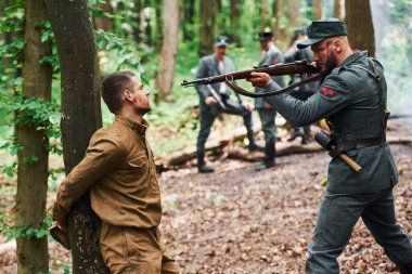 TERNOPIL, UKRAINE - Haziran 2020 UPA Ukrayna İsyancı Ordu filmi. Sahne arkası fotoğrafları. Ağaca bağlanan rehinenin sorgusu.