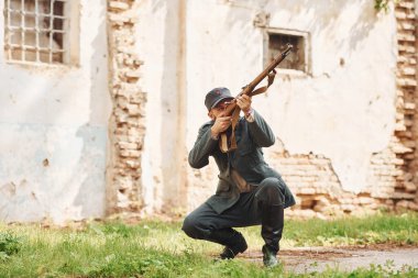 TERNOPIL, UKRAINE - Haziran 2020 UPA Ukrayna İsyancı Ordu filmi. Sahne arkası fotoğrafları. Eski binanın yakınlarında silahlı genç bir asker var..