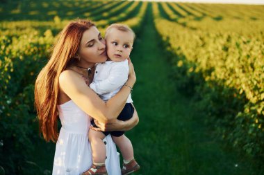 Güneşli bir yaz gününde oğluyla birlikte sahada vakit geçiren pozitif bir anne..