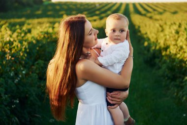 Güneşli bir yaz gününde oğluyla birlikte sahada vakit geçiren pozitif bir anne..