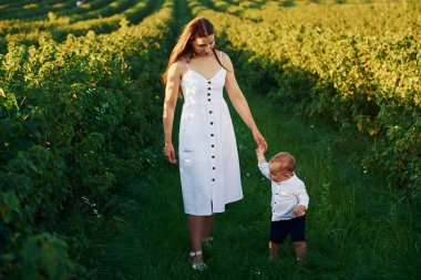 Güneşli bir yaz gününde oğluyla birlikte sahada vakit geçiren pozitif bir anne..