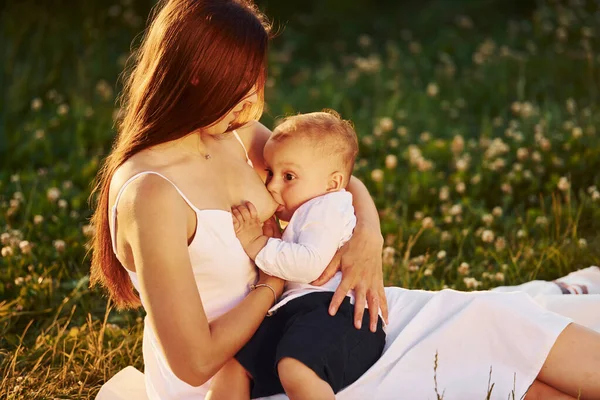 Mutlu anne yaz mevsiminin güneşli günlerinde oğlunu tarlada emziriyor..