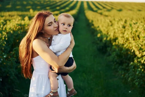 Güneşli bir yaz gününde oğluyla birlikte sahada vakit geçiren pozitif bir anne..
