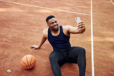 Selfie yapıyorum. Afrikalı Amerikalı adam dışarıda basketbol oynuyor..